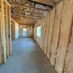 Insulation being installed in a residential interior for energy efficiency.