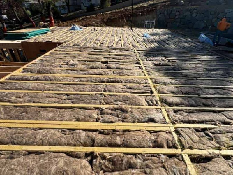 Insulation being installed on a sloped roof for energy efficiency and weather protection.