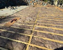 Insulation being installed on a sloped roof for energy efficiency.